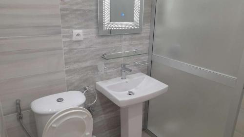 a bathroom with a white toilet and a sink at Le GANGA LODGE in Ndangane