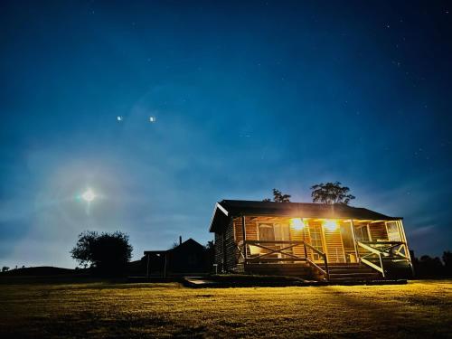 a small wooden house with lights on it at night at Buchan Accommodation in Buchan