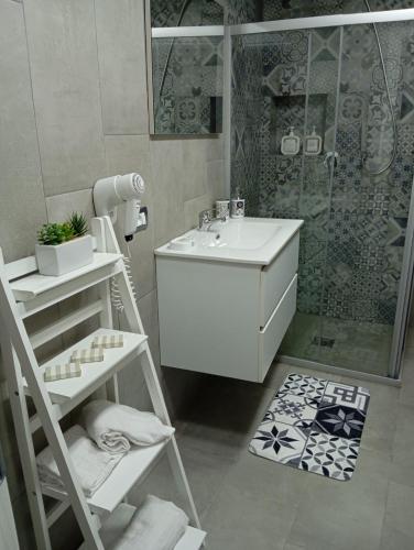 a bathroom with a white sink and a shower at Casa Bijou in Marsala