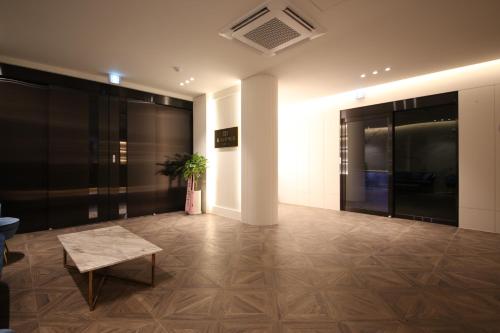a lobby with a bench and a plant in a building at H avenue Hotel Jeonju Deokjin in Jeonju