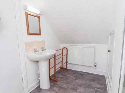 a bathroom with a sink and a mirror at 1A Police House in Whitby