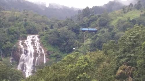 a train is flying over a waterfall at Will Guest Homestay in Ella