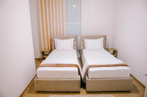 two beds sitting next to each other in a room at Vila Franko in Berat