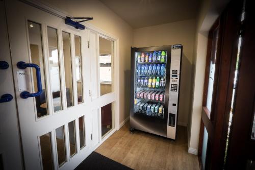 Travelodge Waterford في واتيرفورد: آلة بيع في غرفة مع زجاجات مياه غازية
