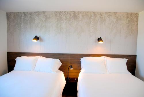 two beds sitting next to each other in a room at Uptown Inn - Limited Service Apart-Hotel in San Diego