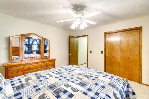 a bedroom with a bed and a ceiling fan at Just a Cast Away Cassville Cabin with Covered Deck in Cassville