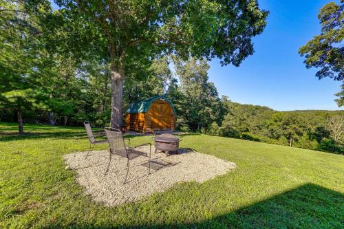 a couple of chairs and a tent in a field at Just a Cast Away Cassville Cabin with Covered Deck in Cassville