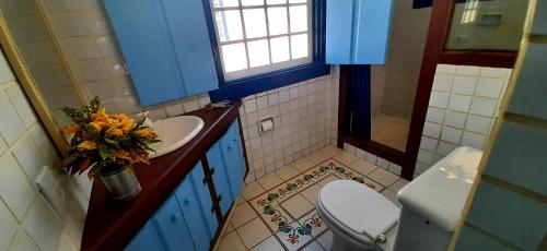 a bathroom with a toilet and a sink and a mirror at Casa Beira Rio in Paraty