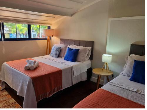 a bedroom with two beds and a window at Casa Beira Rio in Paraty