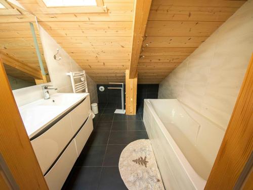 ein Badezimmer mit einer weißen Badewanne, einem Waschbecken und einer Badewanne in der Unterkunft Chalet familial confortable avec spa, proche Gérardmer et station de ski, idéal été et hiver. - FR-1-589-469 in Ban-sur-Meurthe-Clefcy
