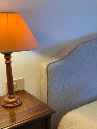 a lamp sitting on a table next to a bed at Fattoria Cirene in Follonica