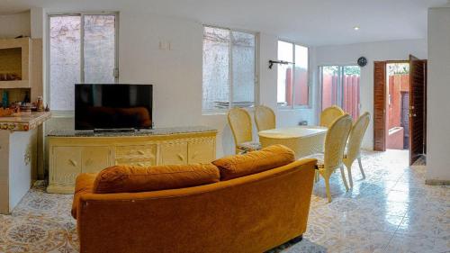 a living room with a couch and a table with chairs at Amplia y cómoda casa in Zihuatanejo