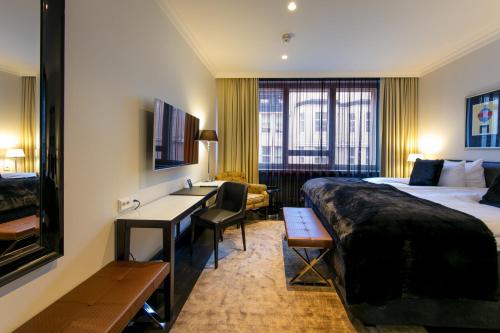 Habitación de hotel con 2 camas y escritorio en Hotel Lilla Roberts, en Helsinki