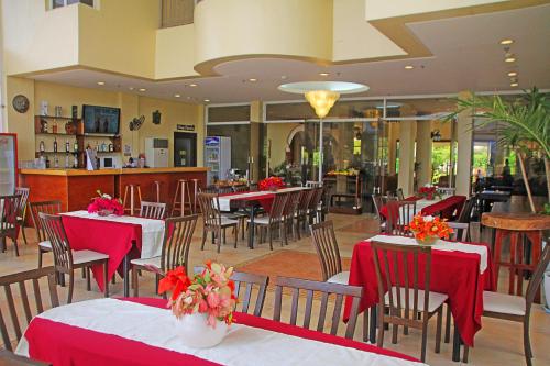 a restaurant with tables and chairs with red table cloth at Hotel Palacio Puerto Princesa in Puerto Princesa City