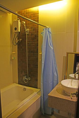 a bathroom with a tub and a sink and a shower at Hotel Palacio Puerto Princesa in Puerto Princesa City