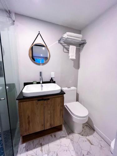 a bathroom with a sink and a toilet and a mirror at Casa Dodo Guatapé in Guatapé