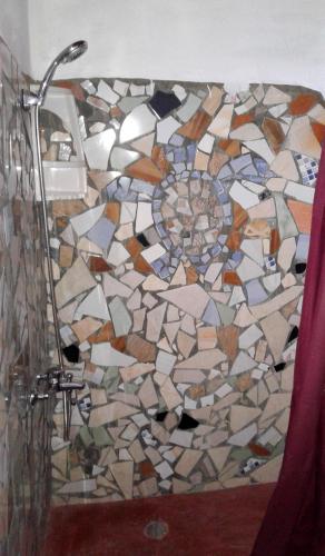 a bathroom with a mosaic shower floor with a shower curtain at Hostel La Ballena Backpacker in Las Galeras