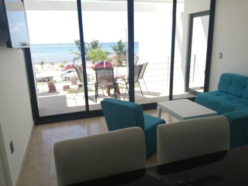 a living room with a blue couch and a view of the beach at Mahaguay - Dpto 2 recamaras frente al mar in Mahahual