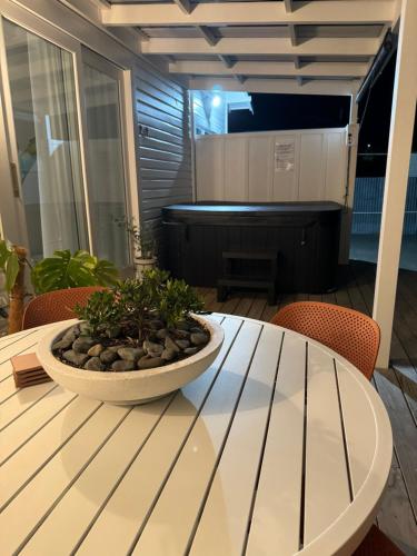 a white table with a bowl of plants on it at Luxury Magnolia Bungalow in Hastings