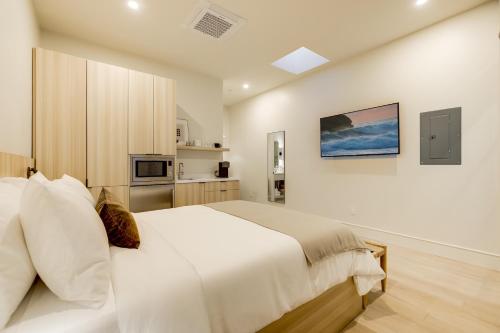 a white bedroom with a large bed and a kitchen at Casa De La Vina - Boutique Suites in Downtown Santa Barbara in Santa Barbara