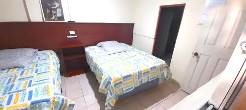a small bedroom with two beds in a room at Hotel Ideal, Your House in Quetzaltenango in Quetzaltenango