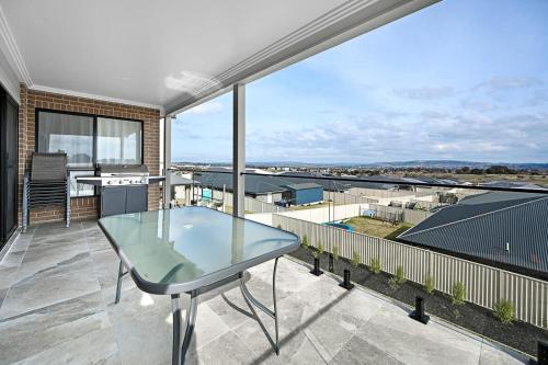 a glass table on a balcony with a view at Hillgrove - Sophisticated & Refined Entertainer in Bathurst