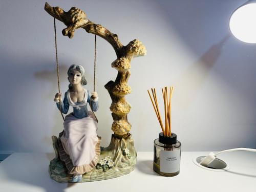 a statue of a woman sitting on a swing at Mirador 2 del Mercado Central - habitacion con baño privado en el centro de la Ciudad Vella in Valencia
