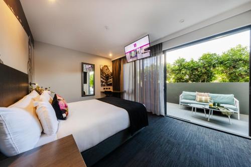 a hotel room with a bed and a large window at Sage Hotel James Street in Brisbane