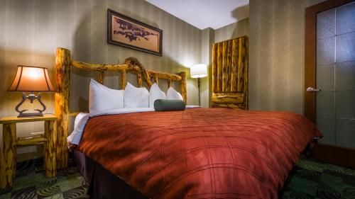 a hotel room with a bed with a red bedspread at Deerfoot Inn and Casino in Calgary