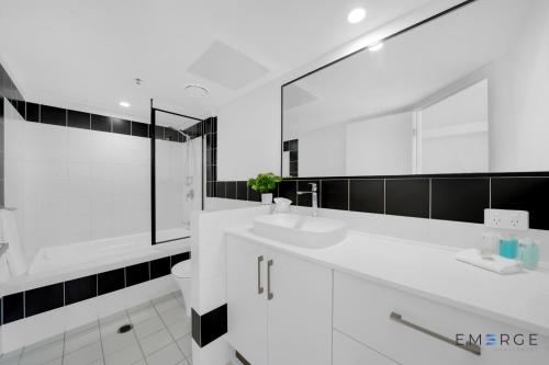 a white bathroom with two sinks and a toilet at Ipanema Holiday Resort in Gold Coast