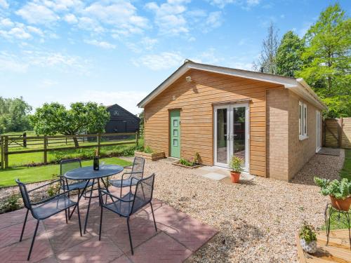 un pequeño cobertizo con una mesa y sillas en un patio en Moor View, en Reepham