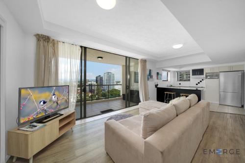 a living room with a couch and a flat screen tv at Ipanema Holiday Resort in Gold Coast
