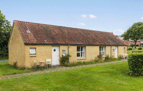 a yellow house with chairs and a grass yard at 1 Bedroom Stunning Home In Nykøbing M in Flade