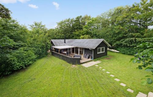 a small house on a grassy field with trees at Nice Home In Hemmet With Kitchen in Hemmet