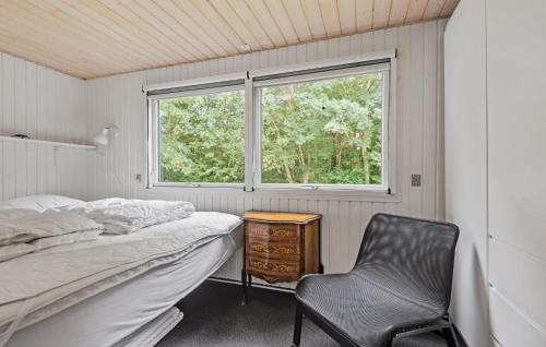 a bedroom with a bed and a chair and a window at Nice Home In Hemmet With Kitchen in Hemmet