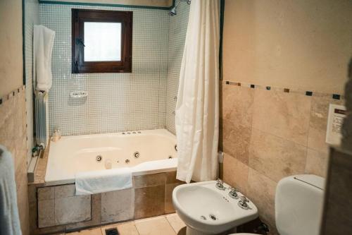 ein Badezimmer mit Badewanne, Toilette und Waschbecken in der Unterkunft Fabuloso descanso en Mendoza, Pileta, Zona Bodegas in Lunlunta