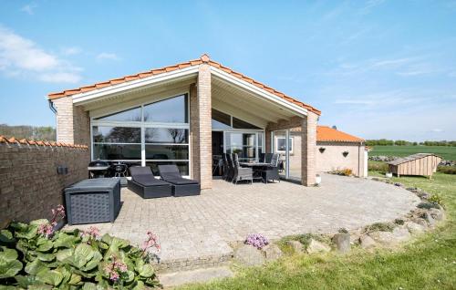 a patio with glass doors and a table and chairs at 4 Bedroom Lovely Home In Faaborg in Fåborg