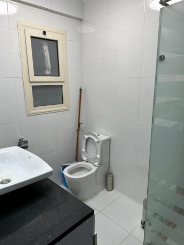 a bathroom with a toilet and a sink and a window at S 22 Marina City in Port Ghalib