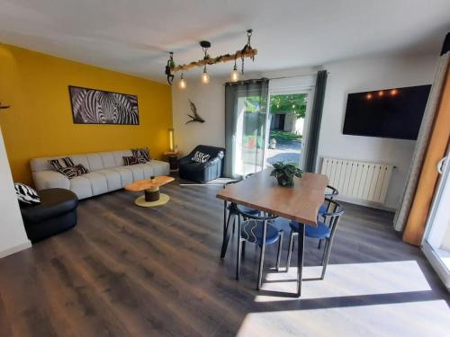 un salon avec une table et un canapé dans l'établissement Maison avec jardin près de Luchon, à Cazaux-Layrisse