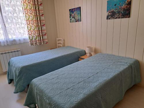 une chambre avec deux lits et une fenêtre dans l'établissement Maison Confortable à 300m de la Plage avec Terrasse et Parking - FR-1-323-432, à Saint-Jean-de-Monts