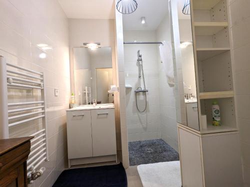 une salle de bain blanche avec une douche et un lavabo dans l'établissement Arcachon Centre: Beau Duplex T3 3* avec Balcon, Parking, à deux pas de la Plage et des Commerces - FR-1-420-107, à Arcachon