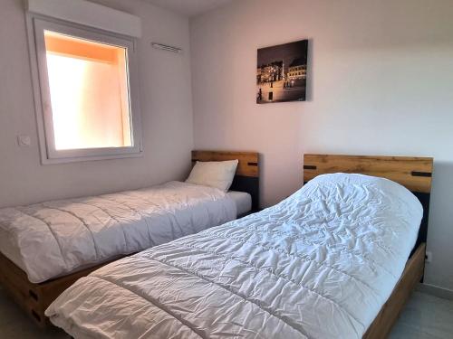 sypialnia z dwoma łóżkami i oknem w obiekcie T4 climatisé à 2 min de la plage, parking privé, terrasse, pour 6 pers - Banyuls-sur-Mer - FR-1-309-359 w mieście Banyuls-sur-Mer