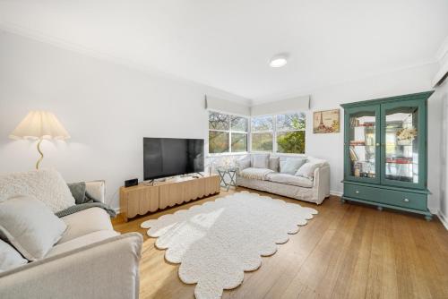 a living room with two couches and a tv at 3-Bed Family Haven with Garden & BBQ Area in Canberra
