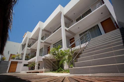 a white building with stairs in front of it at El Hueco Villas in Lobitos
