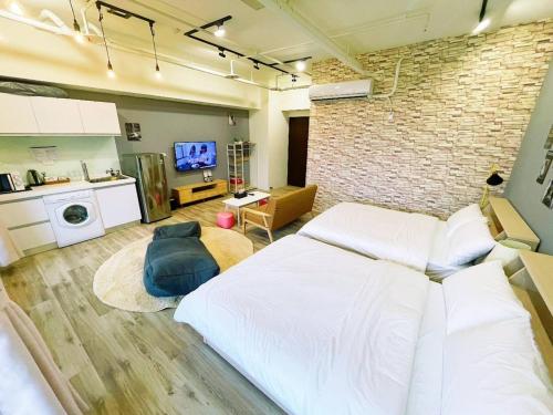 a bedroom with a large bed and a brick wall at 光嶼海溫泉海景無邊際泳池豪華套房 in Hsin-hsing