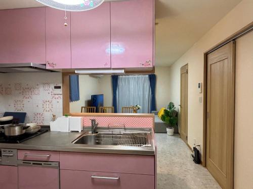 a kitchen with pink cabinets and a sink at Lapis House 201 - 2F & 3F in Tokyo