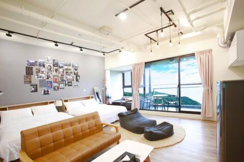 a bedroom with a bed and a couch at 光嶼海溫泉海景無邊際泳池豪華套房 in Hsin-hsing