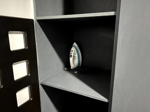 a shelf with a clock in the corner of a room at Departamento Cine en Casa a 5 min de la Plaza de Toros in Pachuca de Soto