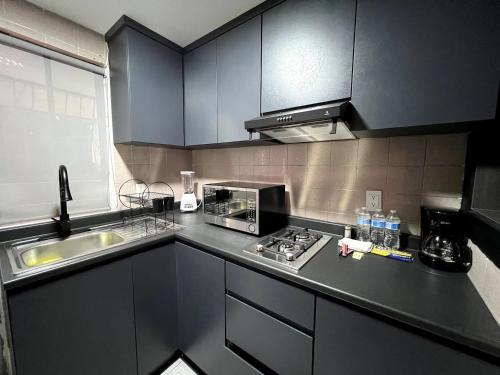 a kitchen with a sink and a stove top oven at Departamento Cine en Casa a 5 min de la Plaza de Toros in Pachuca de Soto