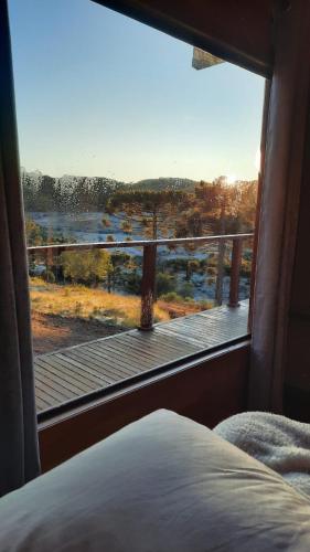a bedroom with a window with a view of a deck at Monte Alegre Pousada in São Joaquim